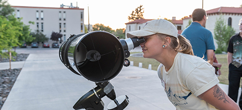 A student looks through a telescope