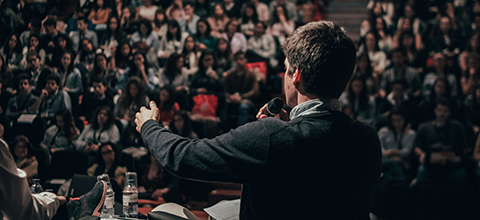 A man giving a speech to a large audience.