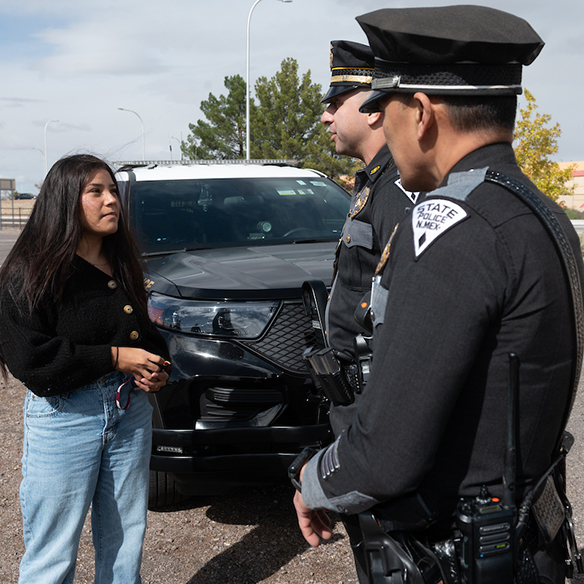 A criminal justice student speaks to two NM state police officers. 