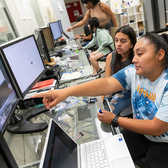 A student looking at data on a desktop computer screen. 