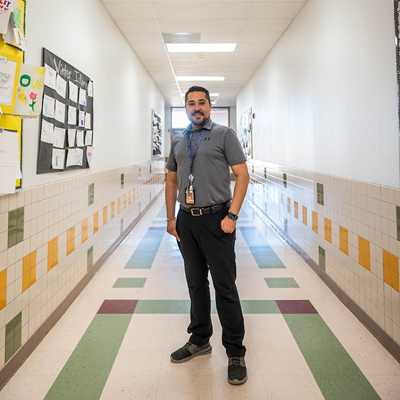 a teacher standing in the hallway of a school