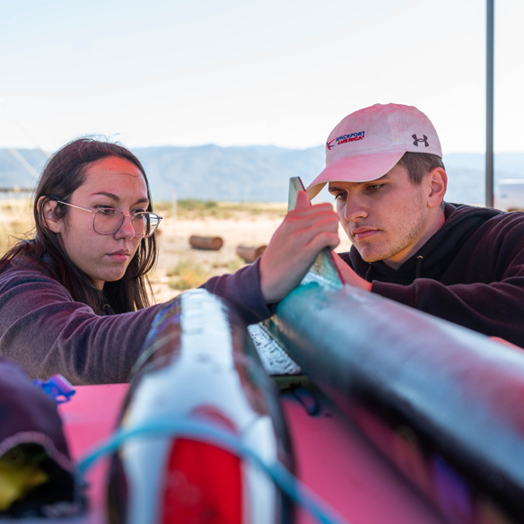 Students in the Atomic Aggies club work on a rocket