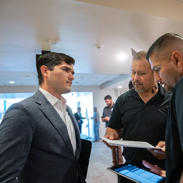 A group of men have a conversation.
