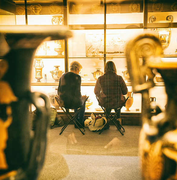 Two visitors brought their own chairs to study historical objects in the British Museum in London, UK.