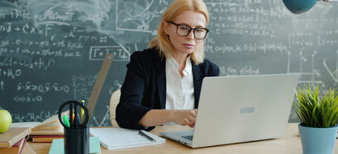 Woman working on computer in classroom