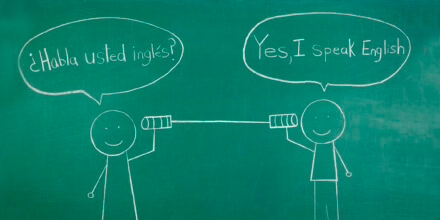 Chalkboard drawing of two children saying hello in Spanish and English