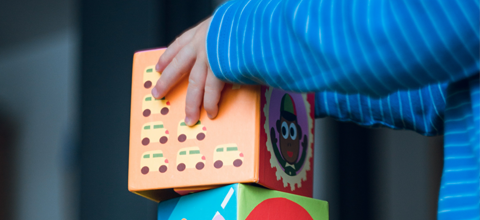 Child placing block on top of another block.