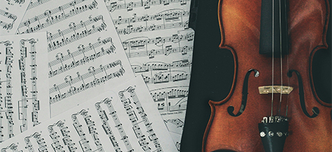 a violin next to sheet music