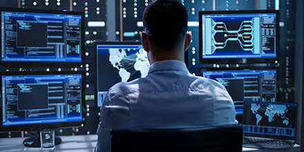 Person in front of multiple computer monitors