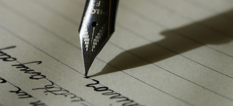 A closeup of a fountain pen and writing