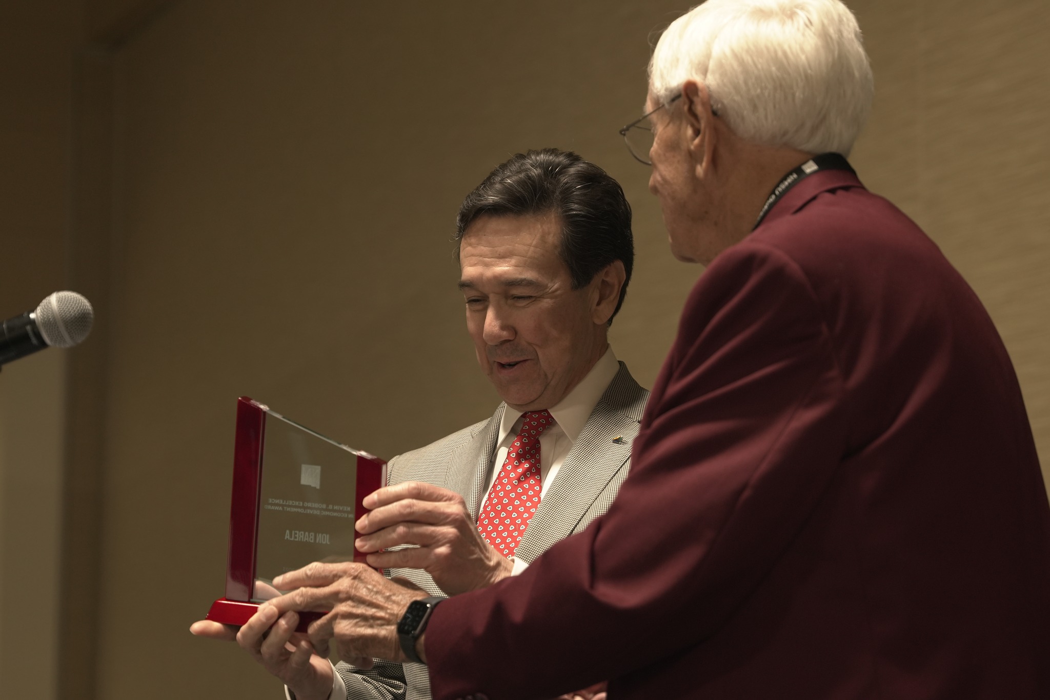 Jon Barela receives an award statue from former NMSU Chancellor Garrey Carruthers